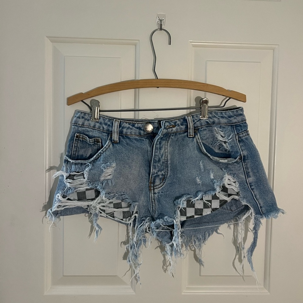 Signature distress jean shorts w/ checker pattern for pockets. Size S/M
